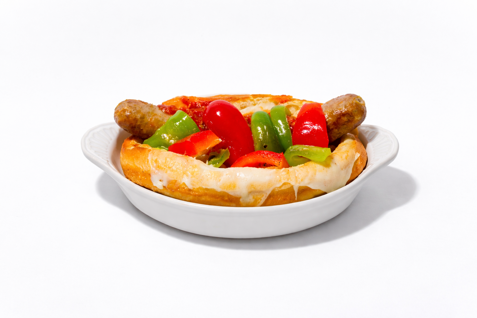 Sausage and peppers sandwich with melted cheese in a white bowl.